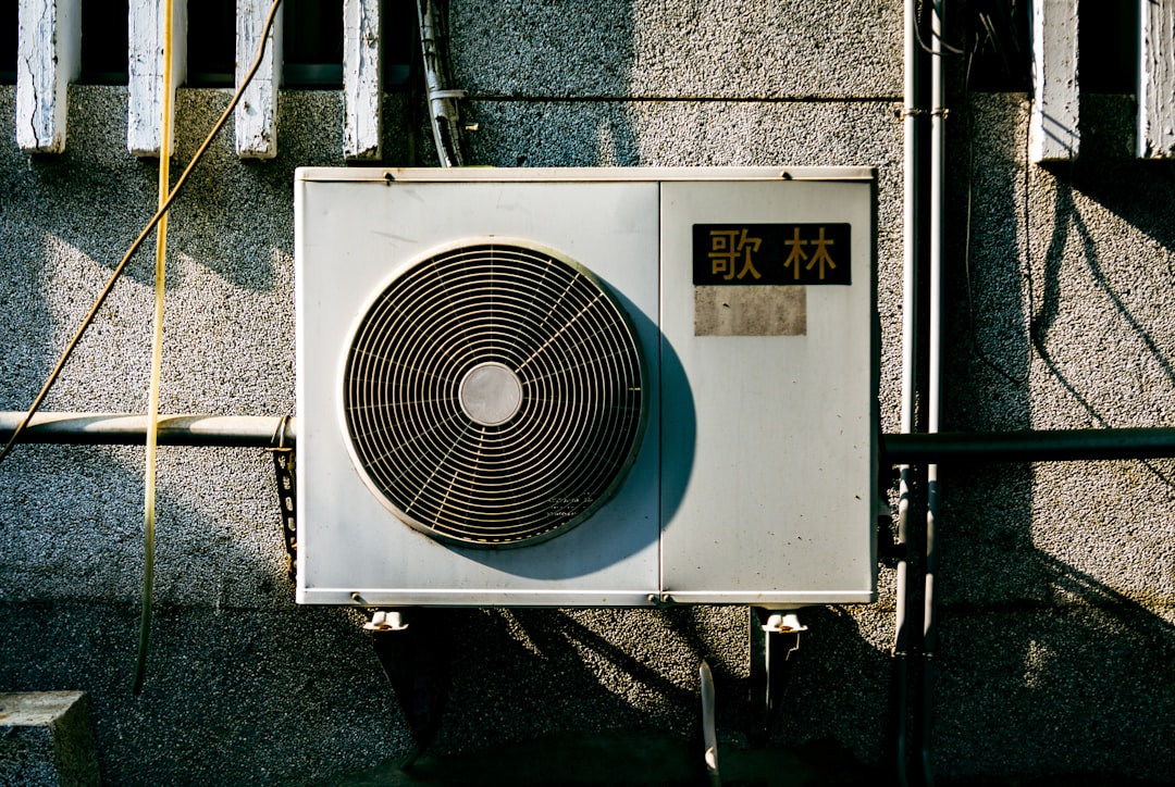 a-wall-mounted-air-conditioner-mounted-on-the-side-of-a-building-1knfo2dpoim